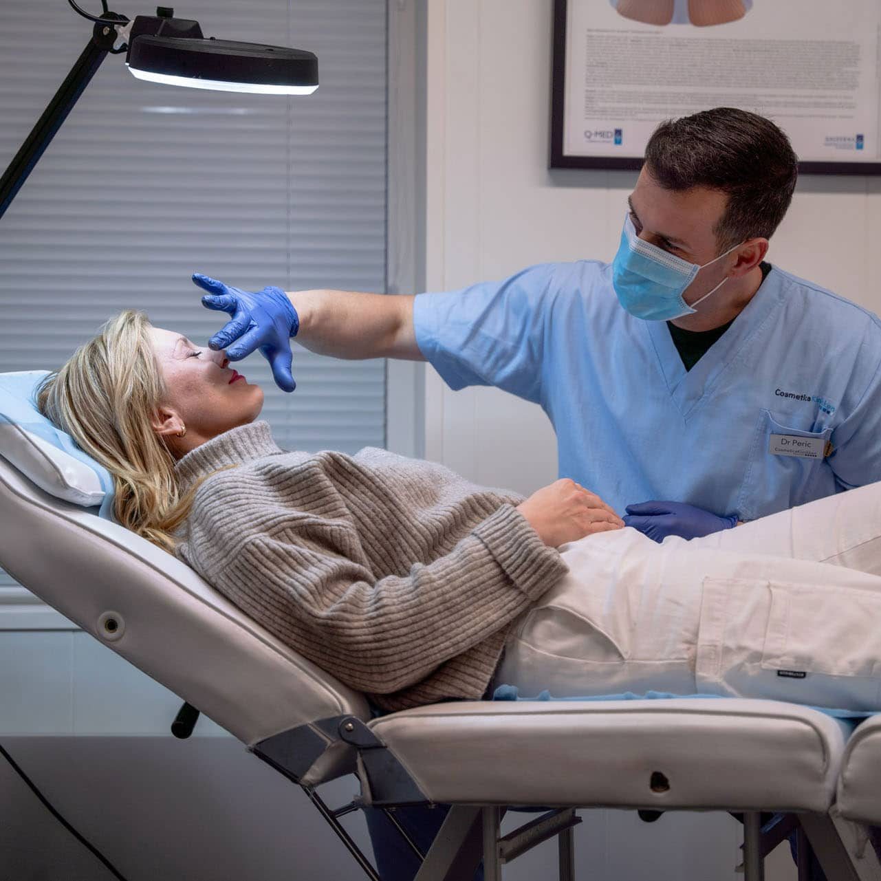 Behandler ved Cosmeticaklinikken i arbeid med en pasient i klinikkens behandlingsstol